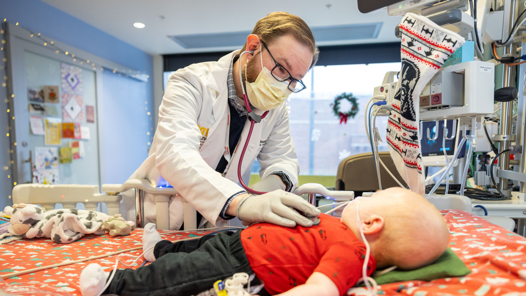 Wesley Peterson, shown with parents Spencer and Julia Peterson and cardiologist Gary Beasley, received a heart transplant before Christmas and is recovering in the UI Health Care Stead Family Children’s Hospital Pediatric ICU on Friday, Dec. 27, 2024. Spencer Peterson is a third-year medical student at the Carver College of Medicine.